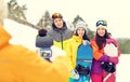 Happy friends with snowboards and smartphone