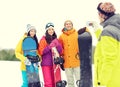 Happy friends with snowboards and smartphone