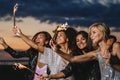 Happy friends with sparklers at sunset