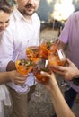 Happy friends spending time together, drinking Aperol spritz cocktail