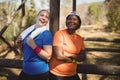 Happy friends standing with arms crossed during obstacle course Royalty Free Stock Photo