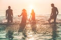 Happy friends swimming on tropical beach at sunset - Group of young people having fun on summer vacation - Youth lifestyle, party Royalty Free Stock Photo