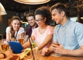 Happy friends with tablet pc and drinks at bar Royalty Free Stock Photo