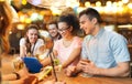 Happy friends with tablet pc and drinks at bar Royalty Free Stock Photo