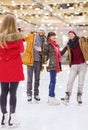 Happy friends taking photo on skating rink Royalty Free Stock Photo