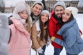 Happy friends taking selfie at ice skating rink outdoors Royalty Free Stock Photo