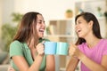 Happy friends toasting with coffee cups at home Royalty Free Stock Photo