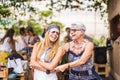 Happy friendship couple of woman young and mature ladies with hippy clothes and dress have fun together dancing and hugging each Royalty Free Stock Photo