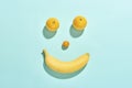 Happy fruit face with banana, tomato and lemons isolated on blue background Royalty Free Stock Photo