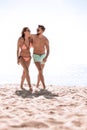 Young couple holding hands and walking on beach. Royalty Free Stock Photo