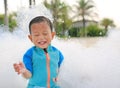 Happy and fun of little asian baby boy in swimming suit having fun in foam party at the pool outdoor Royalty Free Stock Photo