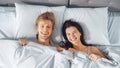 Happy and Fun Young Couple Lying under Blanket on a Bed, Making Silly Faces and Laughing. Lovely Y Royalty Free Stock Photo
