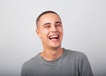 Happy fun young man laughing in casual clothing on grey background with empty copy space. Closeup Royalty Free Stock Photo