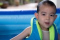 Happy Funny Baby Boy Kid Toddler wearing life jacket playing water in the pool Royalty Free Stock Photo