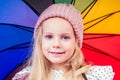 Happy funny beautiful blonde with blue eyes child with rainbow colorful umbrella in the autumn park. Girl kid playing on Royalty Free Stock Photo