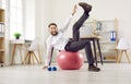 Happy, funny businessman having fitness workout with Swiss ball at work in office Royalty Free Stock Photo