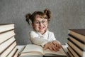 Happy funny caucasian baby girl in glasses reading a book. Emotional girl. To school soon Royalty Free Stock Photo