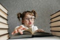 Happy funny caucasian baby girl in glasses reading a book. Emotional girl. To school soon Royalty Free Stock Photo