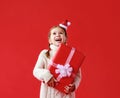 Happy funny child girl    with Christmas gift on red   background Royalty Free Stock Photo