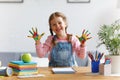Funny child girl draws laughing shows hands dirty with paint Royalty Free Stock Photo