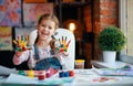 Funny child girl draws laughing shows hands dirty with paint Royalty Free Stock Photo