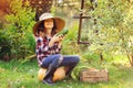 Happy funny child girl in farmer hat and shirt playing and picking autumn vegetable harvest