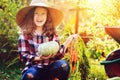 Happy funny child girl in farmer hat and shirt playing and picking autumn vegetable harvest Royalty Free Stock Photo