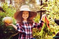 Happy funny child girl in farmer hat and shirt playing and picking autumn vegetable harvest Royalty Free Stock Photo