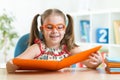 Happy funny child girl in glasses reading a book Royalty Free Stock Photo