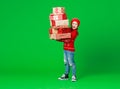 Happy funny child girl in red Christmas hat   with gifts on green   background Royalty Free Stock Photo