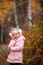 Happy funny child wearing pink raincoat . cute toddler girl playing outdoors in autumn park Royalty Free Stock Photo