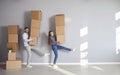 Happy funny couple holds cardboard boxes for moving in new apartment house room Royalty Free Stock Photo