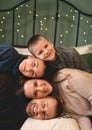 Happy  funny family lying in row looking at camera, smiling children  young adult father and mother laughing bonding Royalty Free Stock Photo