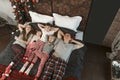 Happy funny family with three children in bedroom in Christmas pajamas. Top view. Young mother father and kids together on bed. Royalty Free Stock Photo