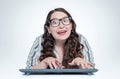 Happy funny girl programmer in glasses with keyboard in front of computer