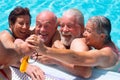 Happy and funny group of senior people in swimming pool enjoying the summer and retirement. Happiness under the bright sun. Blue