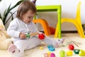 happy funny kid curly baby girl with educational toy blocks flowers. Children play at day care or preschool. Mess in Royalty Free Stock Photo