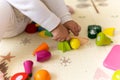 happy funny kid curly baby girl with educational toy blocks flowers. Children play at day care or preschool. Mess in Royalty Free Stock Photo