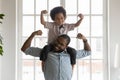 Happy funny kid riding on dads shoulders