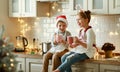 Happy children on Christmas eve,   girl and boy drink hot cocoa drink that they baked together in cozy kitchen at home Royalty Free Stock Photo