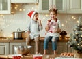 Happy children on Christmas eve,   girl and boy eat cookies that they baked together in cozy kitchen at home Royalty Free Stock Photo