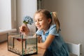 Happy funny little girl watching little goldfish in aquarium, tapping on glass, attracting attention. Royalty Free Stock Photo