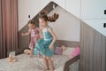 Cute girls jumping on the bed in the room Royalty Free Stock Photo