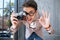 Happy funny male photographer in round glasses taking pictures outdoors Royalty Free Stock Photo