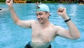 Happy funny man dancing and having fun in swimming pool excited for summer
