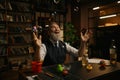 Happy funny senior businessman at desk table under bubble blower Royalty Free Stock Photo