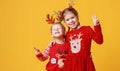 Happy funny surprised emotional children boy and  girl in red Christmas reindeer costume   on yellow   background Royalty Free Stock Photo