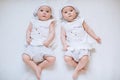 Happy funny twin sisters girls playing at home on a white carpet background. The concept of a happy childhood Royalty Free Stock Photo