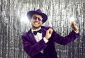 Happy funny young guy wearing purple jacket, hat and sunglasses dancing at party Royalty Free Stock Photo