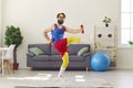 Happy funny young man in retro activewear exercising with dumbbells and laughing Royalty Free Stock Photo